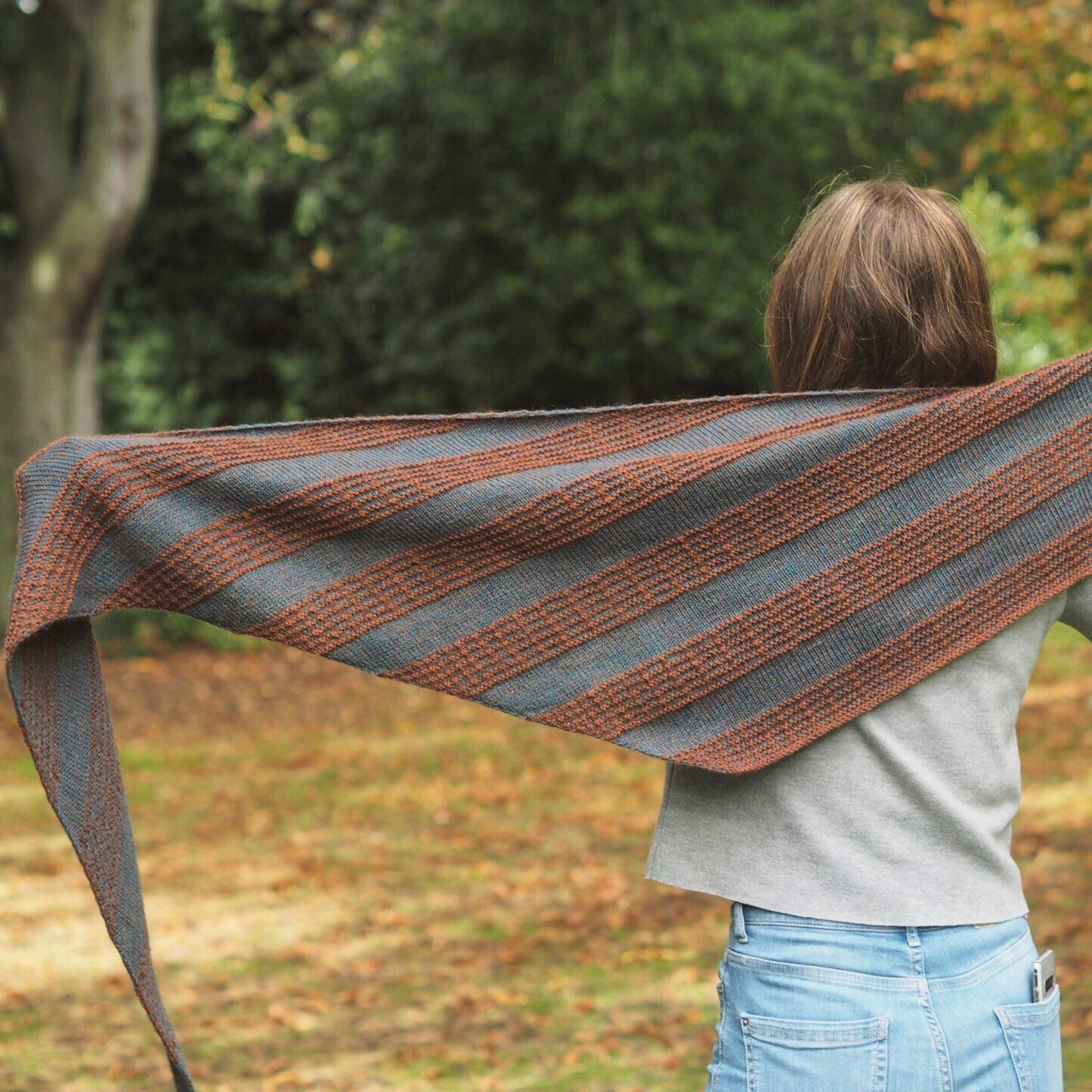 Triangular shawl in brown and blue with guitar fret slipped stitches