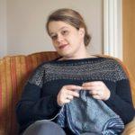 photo of blonde haired woman knitting in an armchair