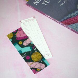 dark green knitters bookmark with needle conversion chart on the reverse