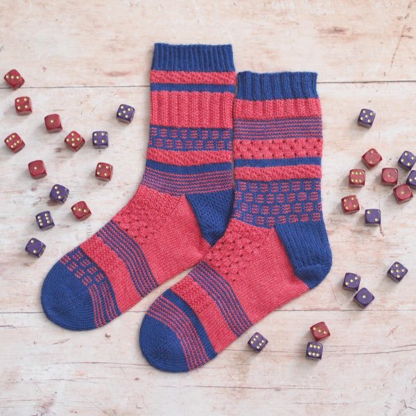 Pink and blue sampler socks laid flat surrounded by dice