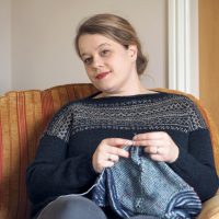 photo of blonde haired woman knitting in an armchair